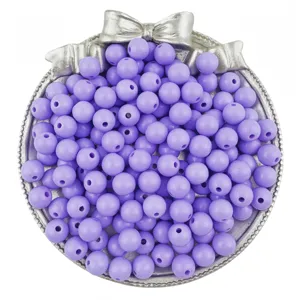 Close up of purple acrylic round loose beads in silver bow tray for DIY jewelry making detail