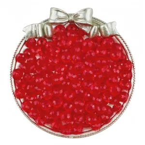 Gros plan détaillé de perles rondes en acrylique rouge dans un plateau décoratif argenté.