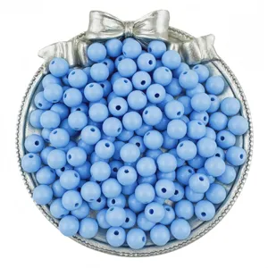 Detailed shot of light blue round beads in a decorative silver tray, perfect for DIY jewelry.