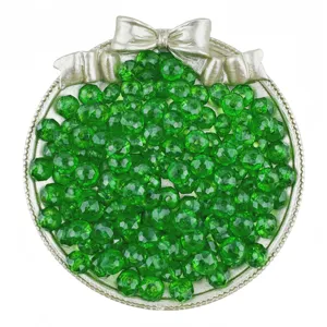 Gros plan de perles rondes en acrylique vert de 8mm dans un plat decoratif pour bijoux DIY.