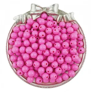 Pink acrylic round beads with holes in a silver bow tray DIY jewelry making supplies.