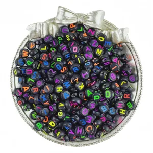 Close-up detail of black acrylic letter beads with colorful alphabet prints for DIY jewelry crafting.