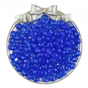Gros plan de perles rondes acryliques transparentes bleues 8mm dans plateau nœud argent.