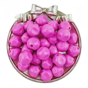 Close-up of vibrant pink acrylic beads in a silver bow tray, perfect for DIY jewelry.
