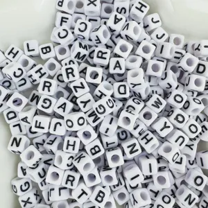 Gros plan de perles alphabet en acrylique carré blanc avec des lettres noires pour loisirs.