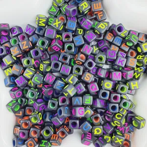 Close-up of black square acrylic alphabet beads with colorful letters for DIY craft projects.