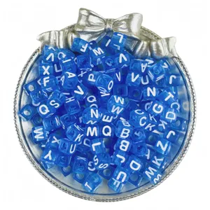 Detail view of blue acrylic alphabet cube beads with white letters for DIY jewelry making.