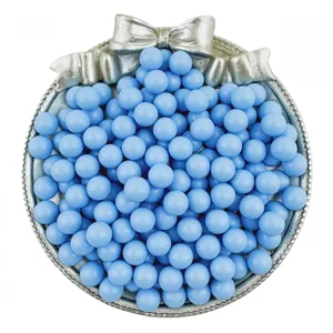 Detailed close-up of light blue acrylic solid round beads displayed in a decorative tray.