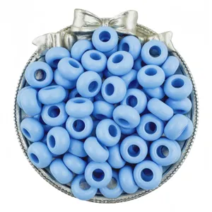 Closeup of light blue acrylic large hole beads inside a decorative silver bowl for DIY crafts.