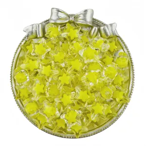 Close up view of translucent yellow acrylic star beads displayed in a decorative silver tray.