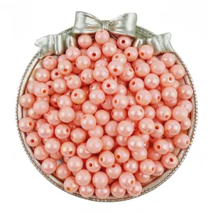 Detailed close-up view of shiny pink acrylic round beads with AB coating in a bow dish.