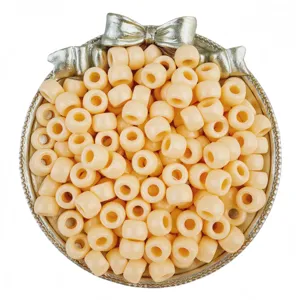 Detailed view of light peach pony barrel beads in a decorative tray for handmade DIY crafts.