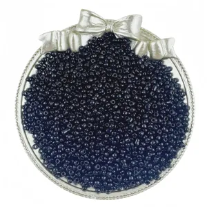 Close-up of black glass seed beads in silver bow tray for DIY jewelry accessories design.