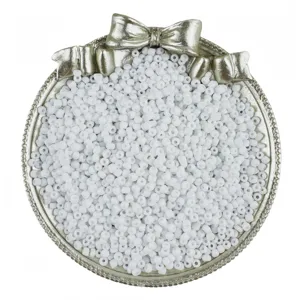 Detailed view of white glass seed beads in decorative silver tray for DIY jewelry making.