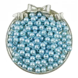 Detailed shot of light blue ABS pearl beads in a bow tray, perfect for DIY craft jewelry.