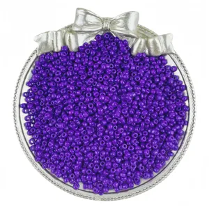 Close-up of vibrant purple glass seed beads neatly displayed in a decorative silver tray.