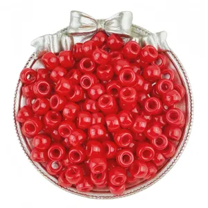 Detailed view of glossy red plastic barrel pony beads in silver decorative tray for DIY crafts.