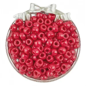 Detailed close-up of vibrant red barrel pony beads displayed inside a decorative silver bowl.