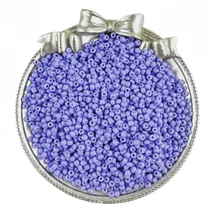 Detail shot of purple glass seed beads in decorative bow dish for DIY jewelry making.