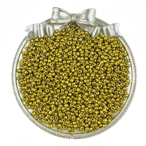 Detailed shot of golden glass seed beads for DIY handmade jewelry bracelets and necklaces.