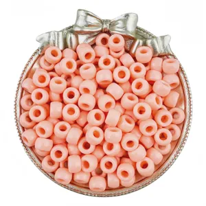 Close-up detail of pink pony barrel beads in decorative bow container for DIY crafts.