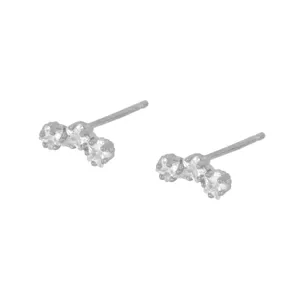 Close-up detail van zilverkleurige oorknopjes met drie fonkelende kleine zirkoniastenen.
