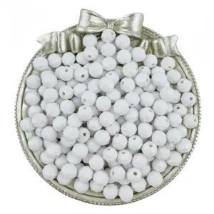 Close-up of white faceted acrylic beads in a silver bow tray, perfect for DIY jewelry making.
