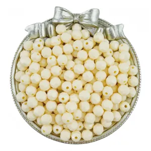 Close-up of 8mm solid light yellow acrylic faceted rhombus beads for DIY jewelry making.