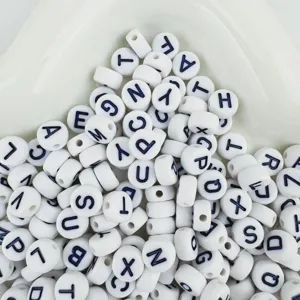 Acrylic letter beads detail shot showing black letters on white flat round beads for jewelry making.