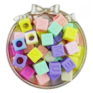 Detail view of colorful acrylic cube letter beads in silver tray for DIY jewelry making.