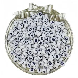 Detail view of white acrylic letter beads featuring clear black alphabets for DIY jewelry making.