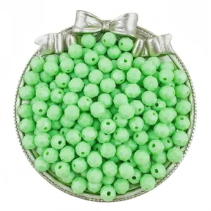 Close-up of 8mm faceted green acrylic beads displayed in a decorative silver bowl.