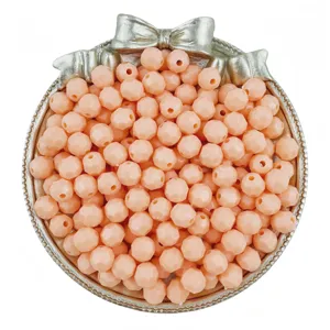 Closeup view of peach pink faceted acrylic beads in a silver tray for DIY handmade jewelry.