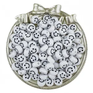 Close-up detail of white acrylic smiley face beads displayed in a decorative silver bowl.