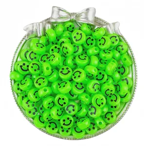 Close-up detail of green acrylic smiley face beads in a silver decorative bowl accessory.