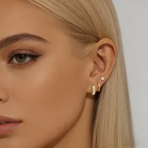 Gedetailleerde close-up van een elegante vergulde zirkonia oorbellen set gedragen door model.