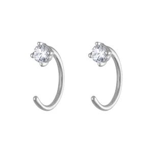 Gros plan détaillé de boucles d'oreilles minimalistes en argent avec zircon étincelant.