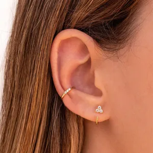 Gros plan détaillé mettant en valeur la manchette d'oreille et les boucles dorées.