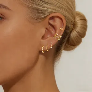 Close-up detail shot of a luxury zircon earring set featuring ear cuffs and delicate hoops on ear.
