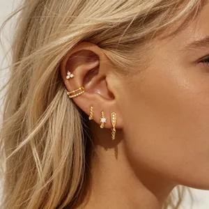 Detailed view of multi-piece gold cubic zirconia stud earrings and stylish ear cuffs set.