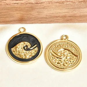 Vue détaillée de pendentifs ronds dorés à vagues avec émail noir, parfaits pour vos bijoux DIY.
