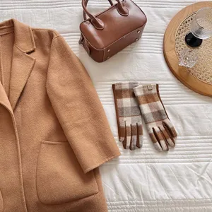Elegante Retro-Karowollhandschuhe neben einem klassischen camel-farbenen Wollmantel