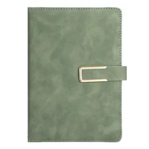 Close-up of sage green faux leather notebook with golden buckle closure