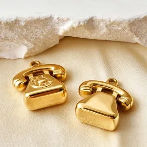 Nahaufnahme von goldenen Vintage-Telefon-Metall-Anhänger-Charms, ideal für DIY-Schmuck.