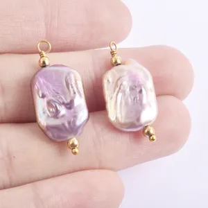 Nahaufnahme unregelmässiger Süsswasserperlen Anhänger mit Golddraht Ösen für DIY Schmuck.