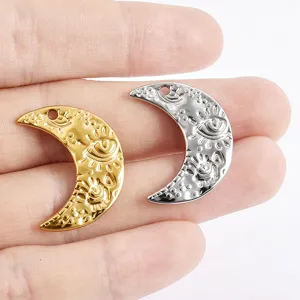 Metal crescent moon evil eye charm pendants in gold and silver, perfect for DIY jewelry making.