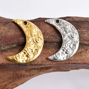 Close-up detail of vintage gold silver moon evil eye metal charms for DIY jewelry making.