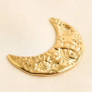 Close-up of gold moon evil eye pendant, vintage metal DIY jewelry charm detail view.
