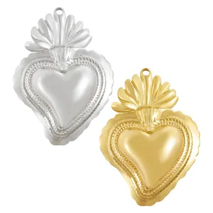 Dettaglio pendente cuore sacro in acciaio inossidabile, accessorio gioiello dorato e argentato.