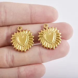 Primo piano di ciondoli a cuore sole in acciaio inossidabile dorato, ciondoli DIY ideali.